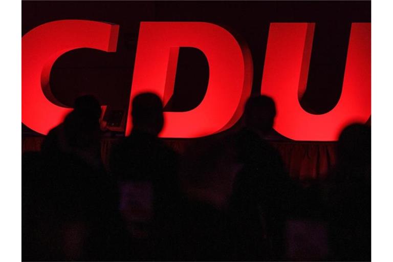 CDU-Delegierte sitzen vor dem Partei-Logo. Foto: Swen Pförtner/dpa/Symbolbild