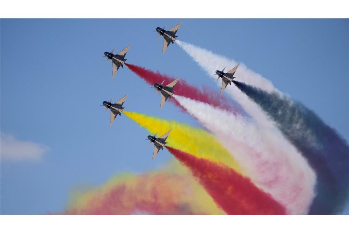 Chinesische Kampfjets fliegen während der ersten Ausgabe der Egypt International Airshow am Flughafen al-Alamein in Formation und "malen" bunte Streifen an den Himmel.