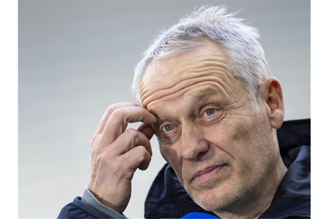 Christian Streich steht vor einem Spiel im Stadion. Foto: Tom Weller/dpa