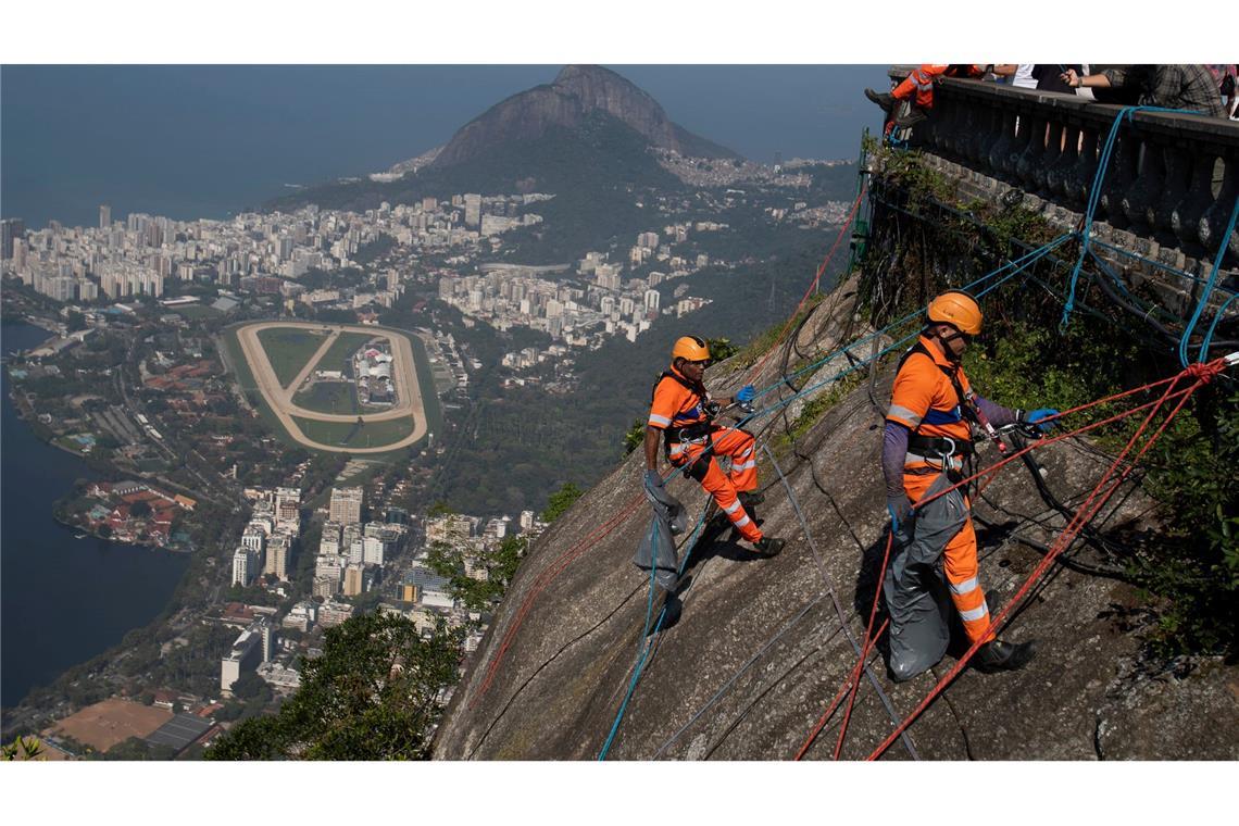 Christusstatue in Rio - Müllsammler beim Abseilen am Hang des Corcovado mit seiner Christusstatue