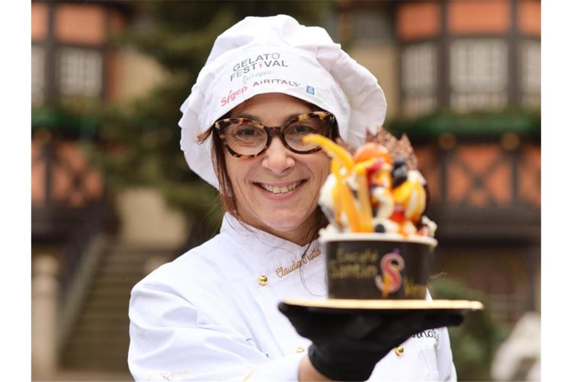 Claudia Trotta steht mit einer Eiskreation auf dem Marktplatz. Foto: Matthias Bein/dpa-Zentralbild/dpa/Archivbild