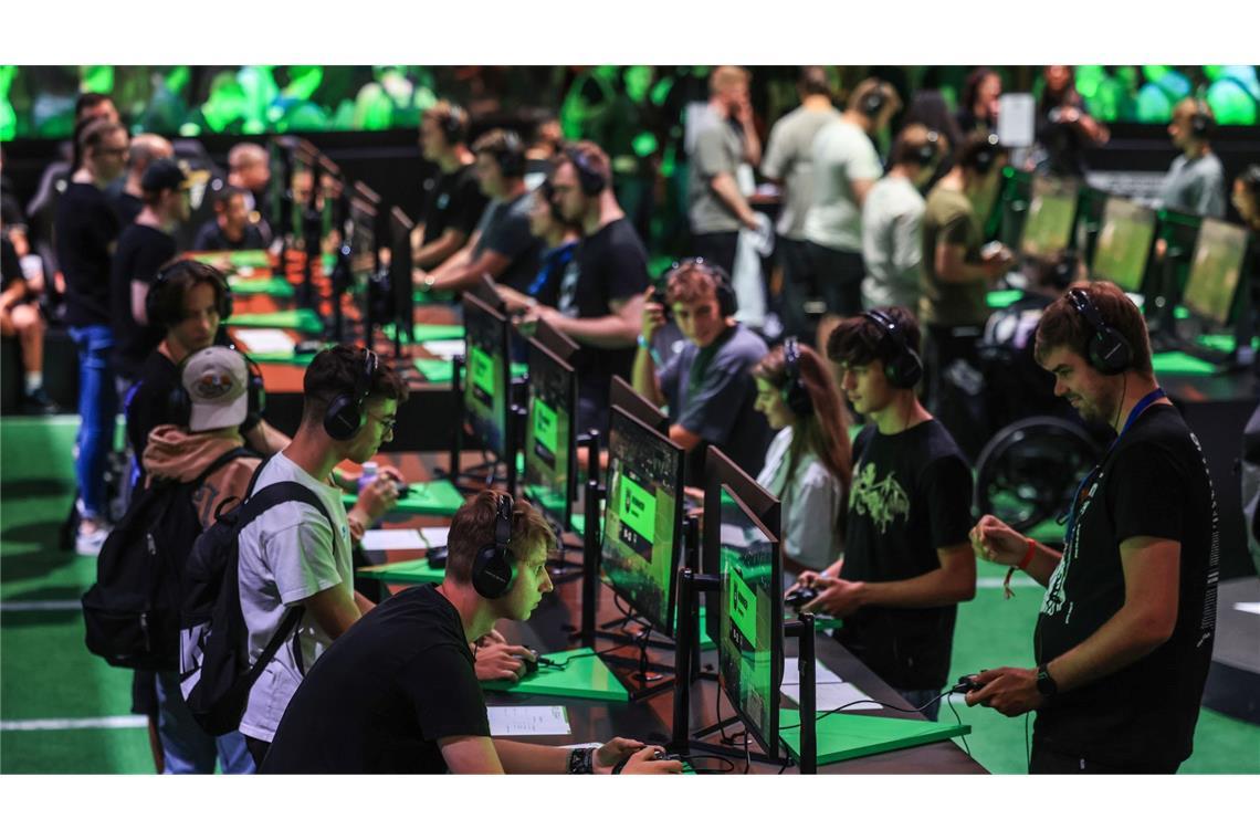 Computerspieler probieren bei der Gamescom Spiele aus.