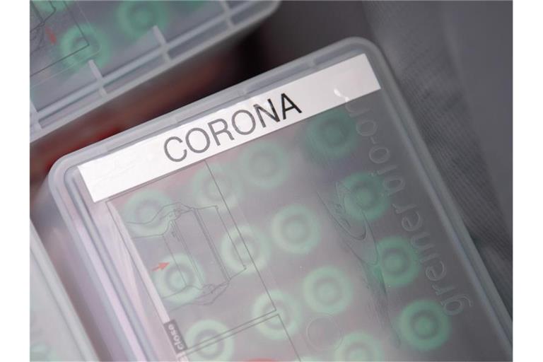 "Corona" steht im Testcenter am Stuttgarter Flughafen auf einer Dose mit durchgeführten Tests, die in ein Labor geschickt werden. Foto: Sebastian Gollnow/dpa