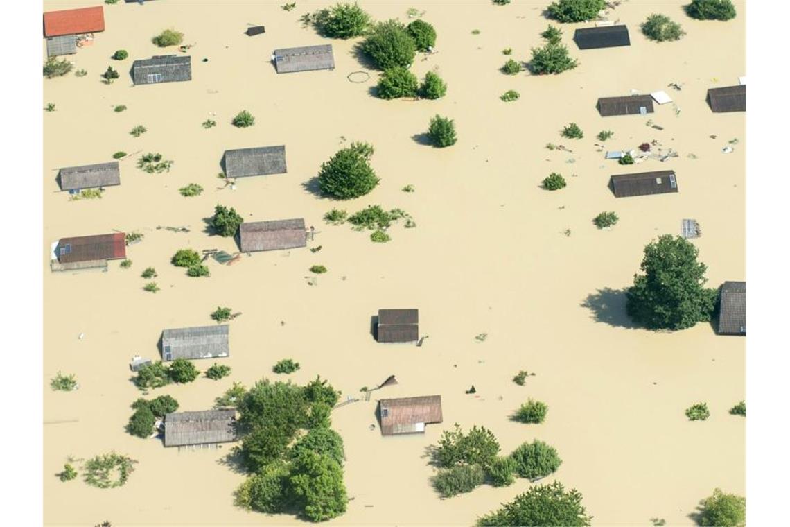 Klimatrend setzt sich fort: 2019 wohl zweitheißestes Jahr Dächer ragen im Juni 2013 nahe Deggendorf (Bayern) nach einem Dammbruch aus dem Hochwasser der Donau. Foto: Armin Weigel/dpa