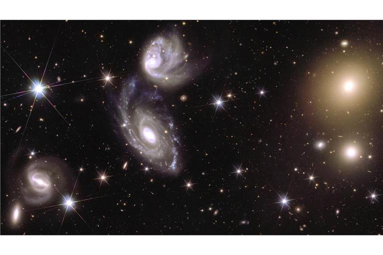 Das Bild zeigt auf der linken Seite die beiden Galaxien ESO 364-G035 und G036n, die 420 Millionen Lichtjahre von uns entfernt miteinander wechselwirken. Auf der rechten Seite des Bildes ist der Galaxienhaufen Abell 3381 zu sehen, der 678 Millionen Lichtjahre von uns entfernt ist. Das Bild ist Teil eines Mosaiks, das aus Bildern des Esa-Weltraumteleskops „Euclid“ zusammengefügt wurde.