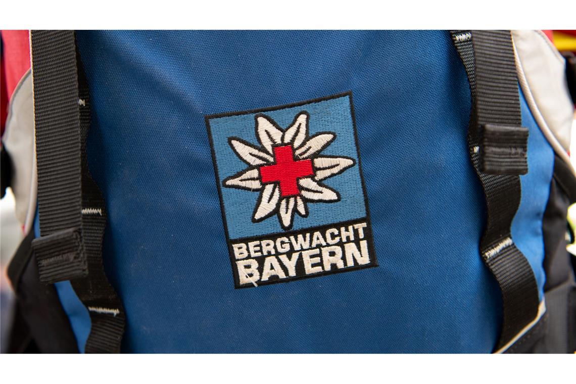 Das Logo der Bergwacht ist an einem Rucksack zu sehen. Bei Oberstdorf musste die Bergwacht nun einen Mann retten, der ohne richtige Ausrüstung und Erfahrung zwei Nächte in den Bergen verbrachte. (Archivfoto-Illustration)