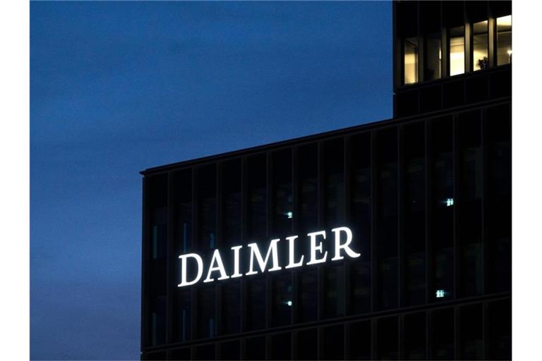 Das Logo der Daimler AG ist in der Morgendämmerung auf der Zentrale des Autokonzerns zu sehen. Foto: Marijan Murat/dpa