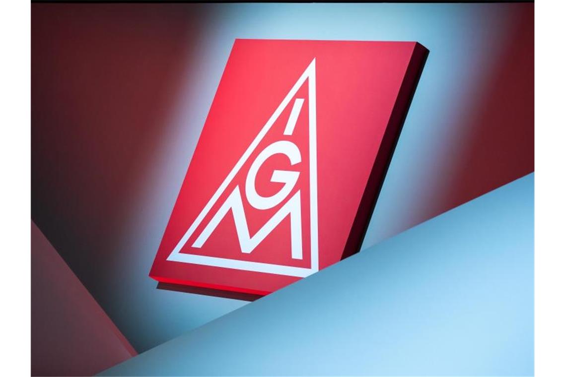 Das Logo der IG Metall hängt über einer Bühne. Foto: Daniel Karmann/dpa/Symbolbild