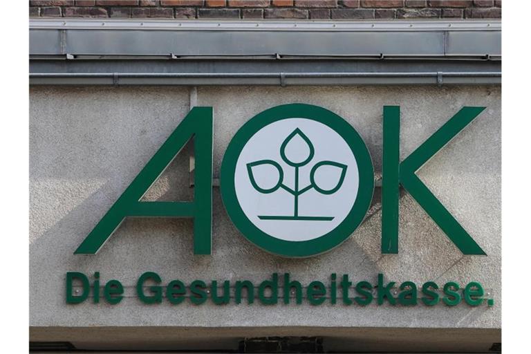 Das Logo der Krankenkasse AOK, aufgenommen am Hauptgebäude der AOK Sachsen-Anhalt. Foto: Jens Wolf/dpa-Zentralbild/dpa/Archiv