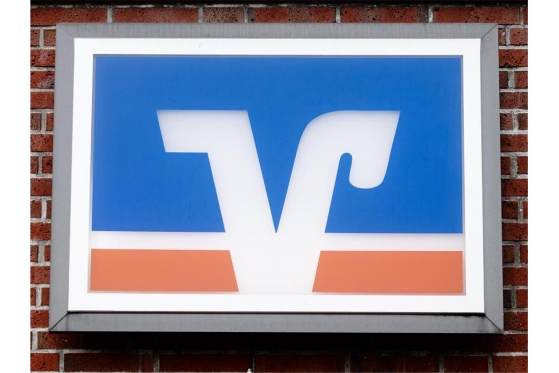 Das Logo der Volks- und Raiffeisenbanken hängt über einer Geschäftsstelle. Foto: Markus Scholz/dpa/Archivbild