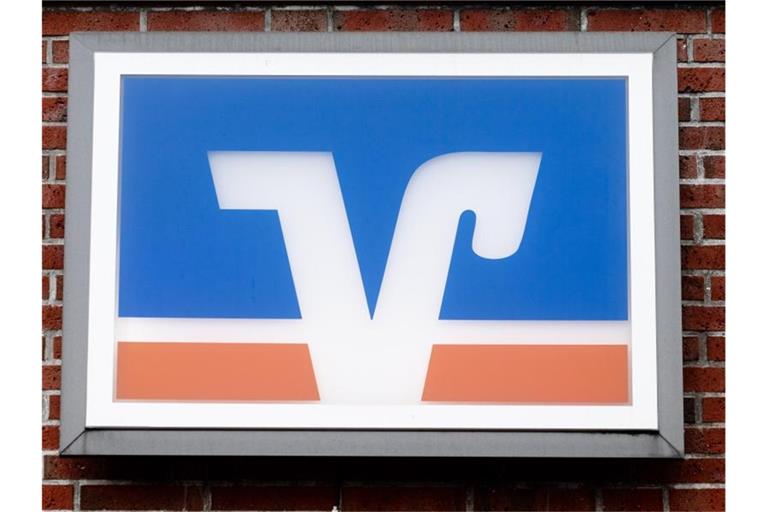 Das Logo der Volks- und Raiffeisenbanken hängt über einer Geschäftsstelle. Foto: Markus Scholz/dpa/Archivbild