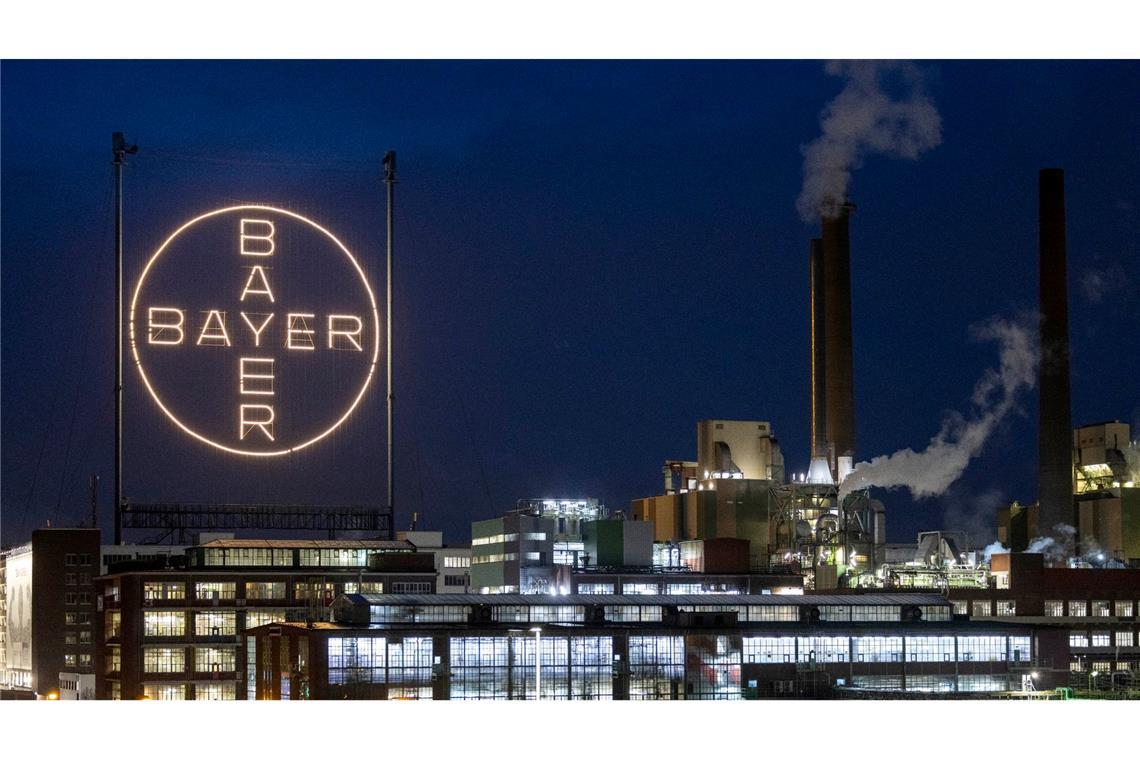 Das Logo des Unternehmens leuchtet auf dem Werksgelände in Leverkusen.
