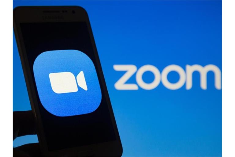 Das Logo des Videokonferenzdienstes Zoom ist auf einem Smartphone-Bildschirm (l) zu sehen. Foto: Andre M. Chang/ZUMA Wire/dpa/Symbolbild