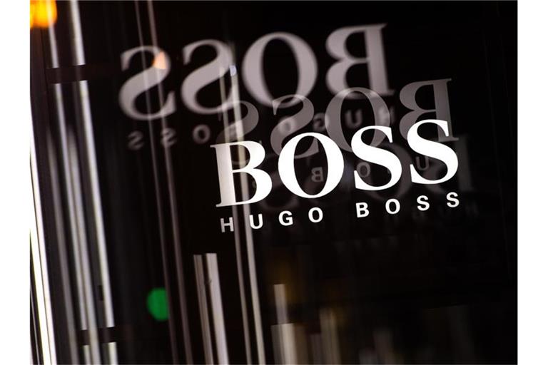 Das Logo von Hugo Boss spiegelt sich in einem Schaufenster. Foto: Sebastian Gollnow/dpa/Symbolbild