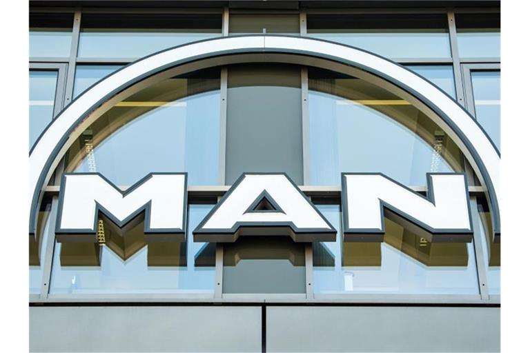 Das MAN Logo hängt an der Fassade eines Bürogebäudes. Foto: Peter Kneffel/dpa/Symbolbild
