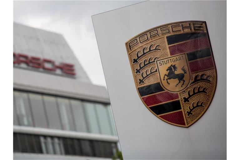 Das Porsche Logo ist vor einem Gebäude des Automobilherstellers zu sehen. Foto: Christoph Schmidt