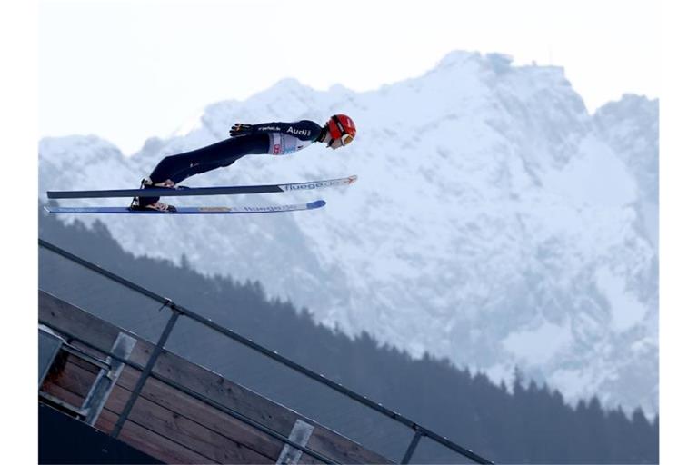 David Siegel aus Deutschland springt beim Probedurchgang vor der Zugspitze. Foto: Daniel Karmann/dpa