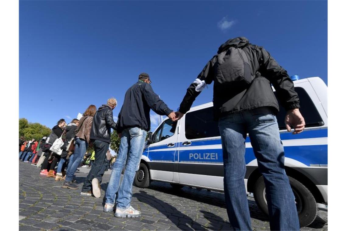 Demonstranten bilden am Samstag in Konstanz eine Menschenkette. Foto: Felix Kästle/dpa