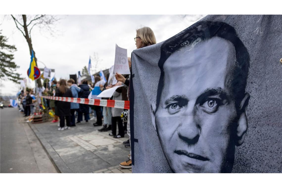 Demonstranten halten vor dem russischen Generalkonsulat in Bonn ein Banner mit dem Porträt des gestorbenen Alexej Nawalny.