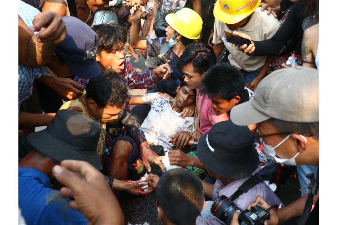 Seit Putsch in Myanmar mindestens 138 Demonstranten getötet Demonstranten umringen einen Verletzten bei einem Protest gegen den Militärputsch in Yangon. Foto: Uncredited/AP/dpa