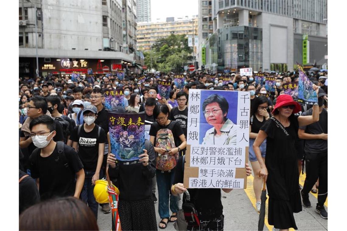 Demonstranten ziehen mit Transparenten durch das Hongkonger Viertel Mong Kok. Foto: Vincent Thian/AP