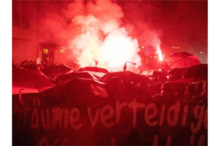 Demonstranten zünden bei einer Demonstration Bengalische Feuer. Foto: Christophe Gateau/dpa