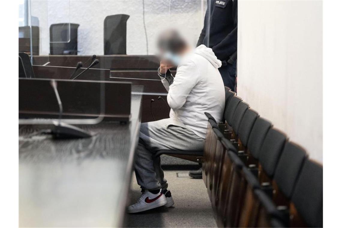 Wenn Ehrgefühl tötet: Mann wegen blutigen Mordes verurteilt Der Angeklagte in einem Mordprozess sitzt auf einer Bank im Landgericht Stuttgart. Foto: Marijan Murat/dpa/Aktuell