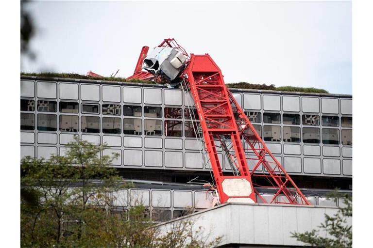 Der Ausleger eines umgestürzten Baukrans lehnt an einer Hauswand. Foto: Matthias Balk/dpa