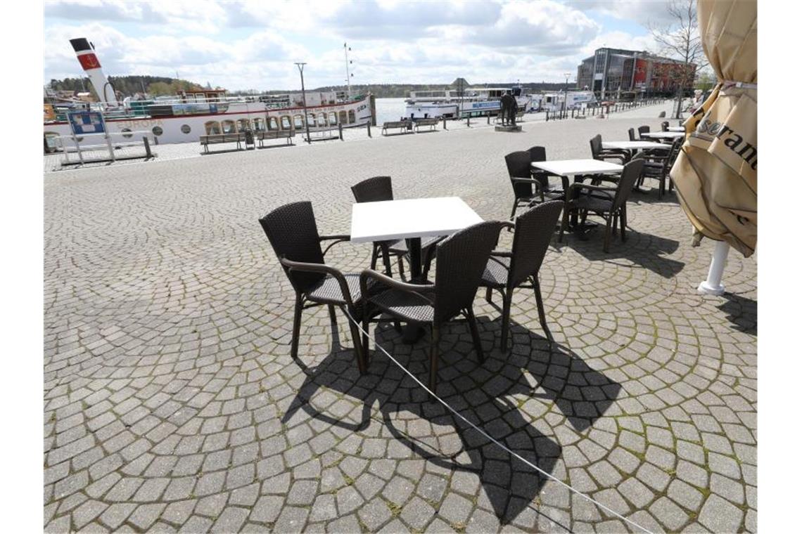 Länder ringen um Lockerungen - Spahn mahnt zur Vorsicht Der Außenbereich eines Cafés im Stadthafen in Waren an der Müritz ist menschenleer. Foto: Bernd Wüstneck/dpa-Zentralbild/dpa