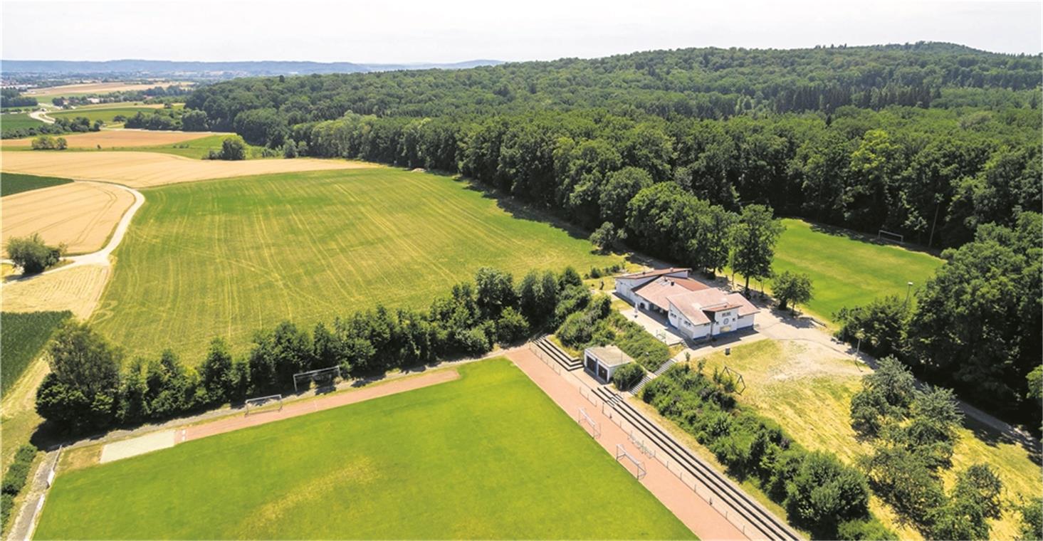 Suche nach Trainingsgelände erfolgreich Der bisherige Trainingsplatz (im Foto rechts hinter dem Vereinsgebäude) soll in Zukunft nicht mehr genutzt und wieder aufgeforstet werden. Auf der freien Grünfläche (hinten) im Anschluss an den Rasenplatz (vorne) wird ein Kunstrasenplatz errichtet. Foto: A. Becher