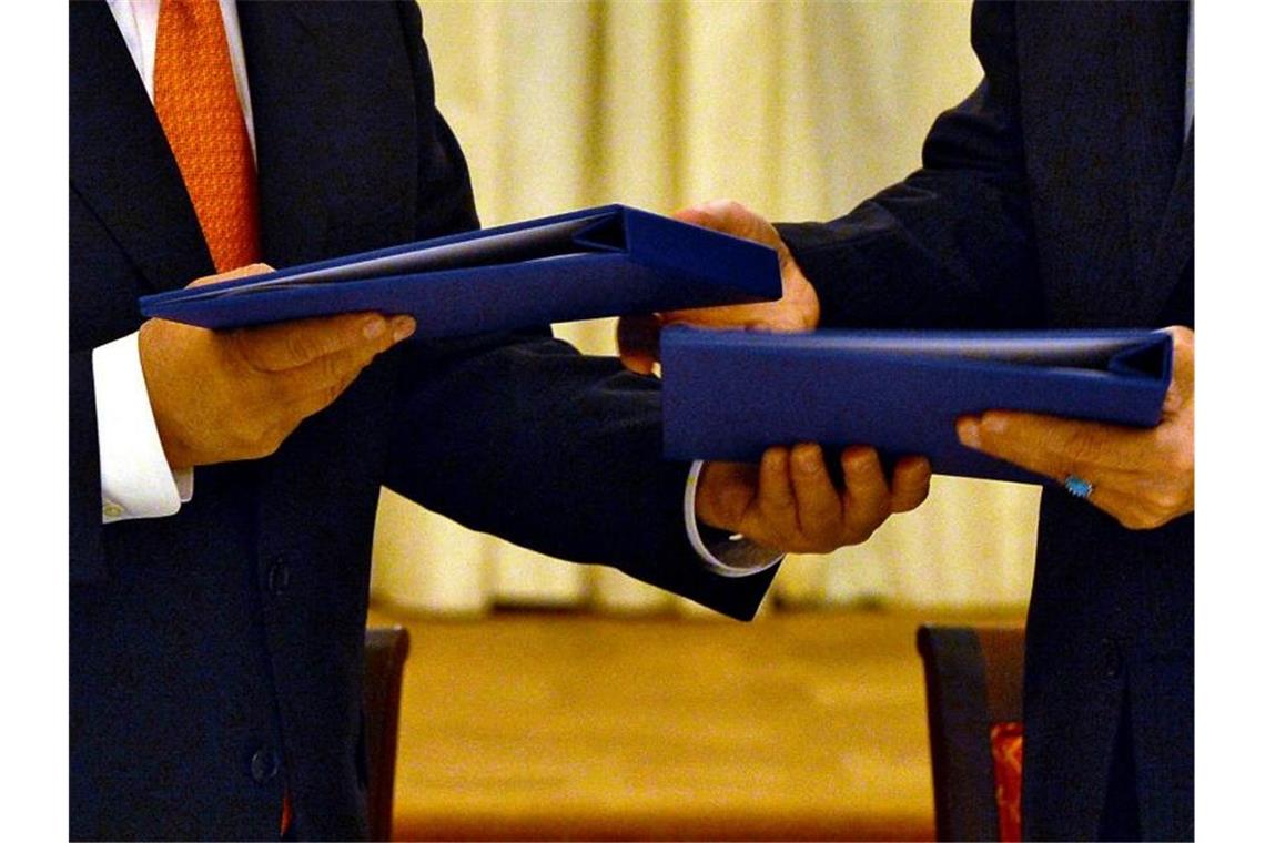 Iran-Atomabkommen: EU arbeitet an Rückkehr der USA Der damalige Generaldirektor der IAEO, Yukiya Amano (l), und der Leiter der iranischen Atomenergiebehörde, Ali Akhbar Salehi, tauschen am 14.07.2015 in Wien die unterschriebenen Verträge, die das iranische Atomprogramm regeln sollen. Foto: Dean Calma/IAEA/dpa