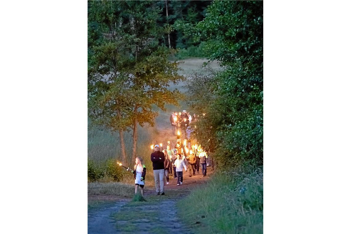 Der Fackelzug bahnt sich seinen Weg zum aufgestapelten Holz fürs Sonnwendfeuer. ...