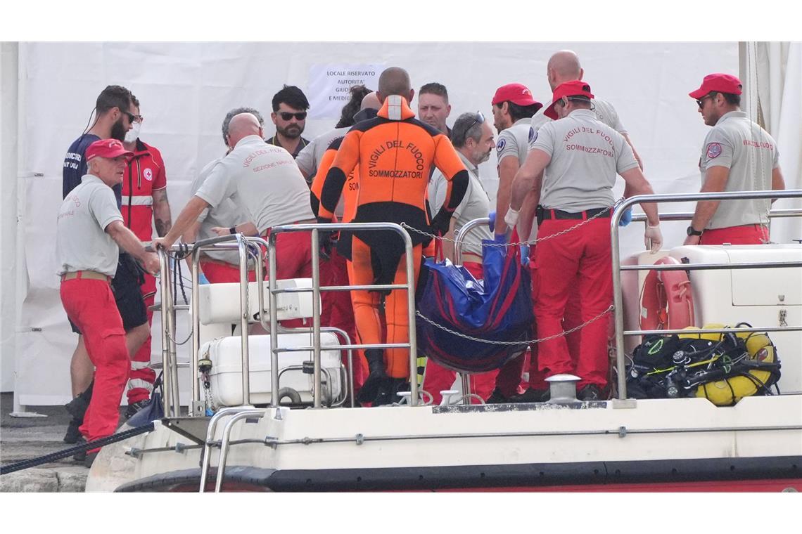 Der fünfte Leichensack wird im Hafen von Porticello von Rettungskräften an Land gebracht, die nach den sechs Touristen suchen, die vermisst werden, nachdem die Luxusyacht Bayesian am Montag in einem Sturm gesunken war.