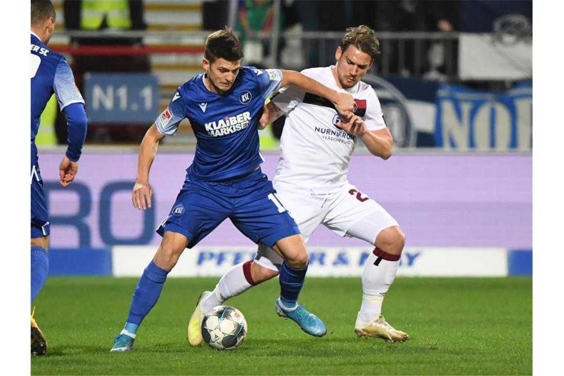 „In mir brodelt ein Vulkan“: KSC enttäuscht nach Rückschlag Der Karlsruher Marvin Wanitzek (l.) und der Nürnberger Oliver Sorg kämpfen um den Ball. Foto: Uli Deck/dpa