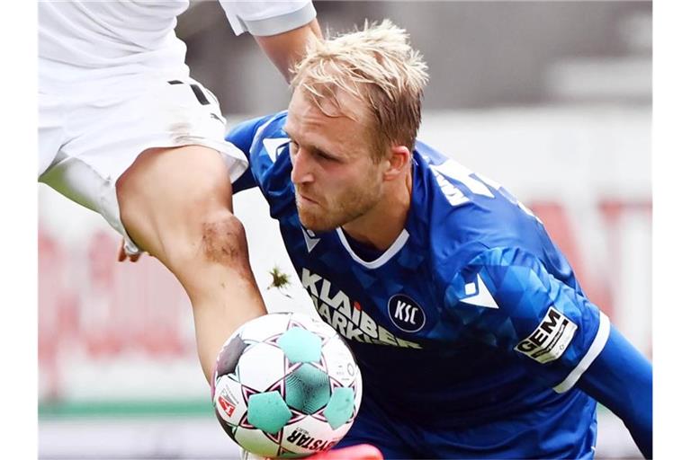 Der Karlsruher Philipp Hofmann (r) und der Sandhausener Julius Biada kämpfen um den Ball. Foto: Uli Deck/dpa/Archivbild