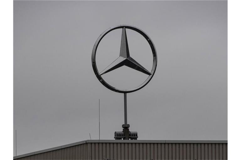 Der Mercedes-Benz-Stern ist auf dem Dach eines Gebäudes zu sehen. Foto: Paul Zinken/dpa/Bildarchiv