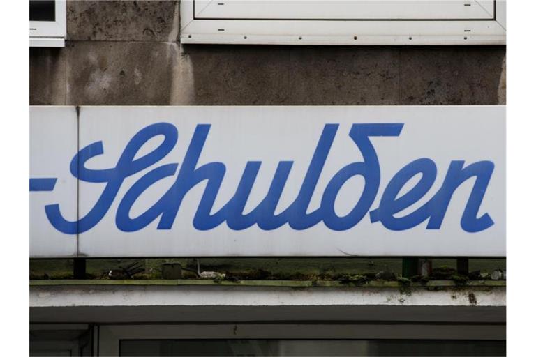 Der Schriftzug „Schulden“ steht über einem leeren Ladenlokal. Die Schuldenuhr des Bundes der Steuerzahler tickt so schnell wie nie zuvor. Foto: Rolf Vennenbernd/dpa