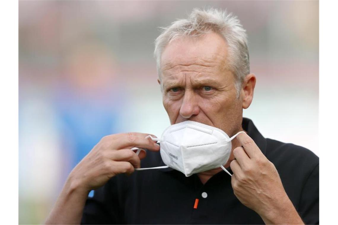 Der Trainer Christian Streich vom SC Freiburg steht auf einem Platz. Foto: Daniel Karmann/dpa