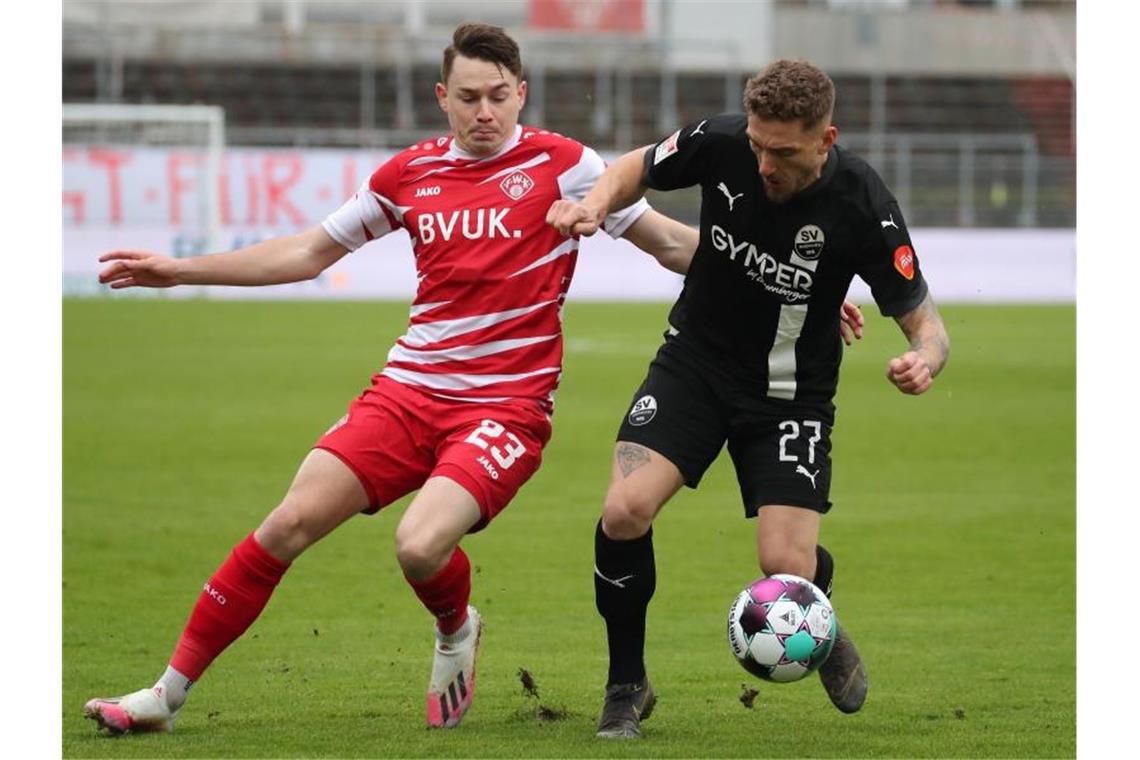 Kickers verlieren Kellerduell bei Schiele-Rückkehr Der Würzburger Florian Flecker (l) kämpft mit Robin Scheu von Sandhausen um den Ball. Foto: Daniel Karmann/dpa