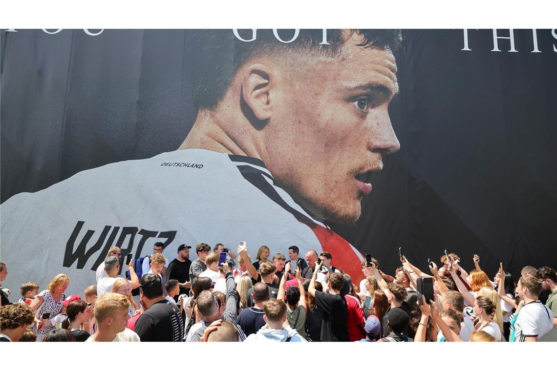 Deutschlands Florian Wirtz (M) gibt bei einer offiziellen Autogramstunde von Adidas in Herzogenaurauch Autogramme an die wartenden Fans vor dem Gebäude.