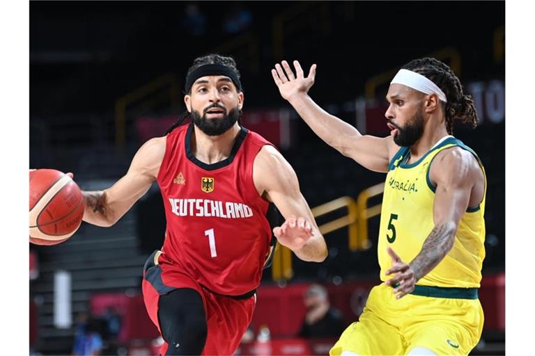 Deutschlands Joshiko Saibou (l) wird vom Australier Patty Mills verteidigt. Foto: Swen Pförtner/dpa