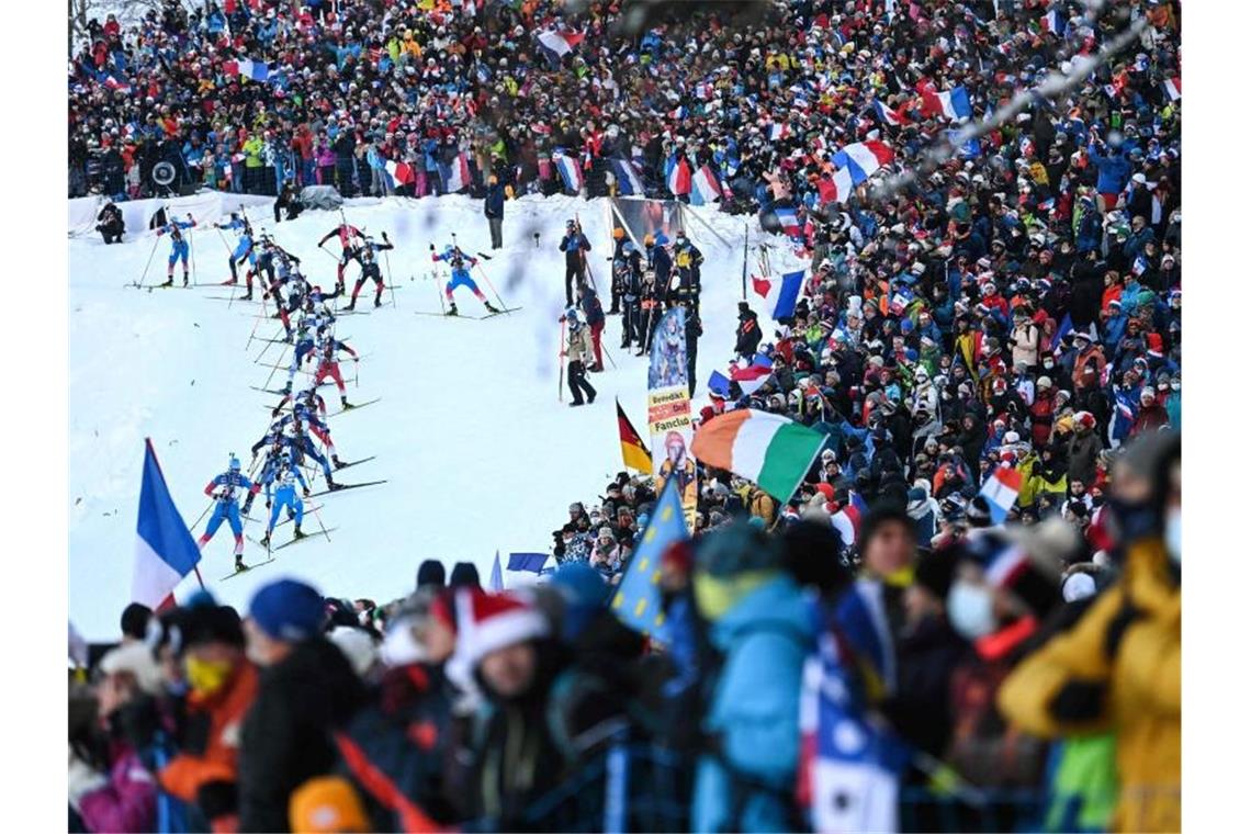 Die Athleten sind in Aktion auf der Strecke, während die Fans dicht gedrängt stehen und zuschauen. Foto: Olivier Chassignole/AFP/dpa/Bildarchiv