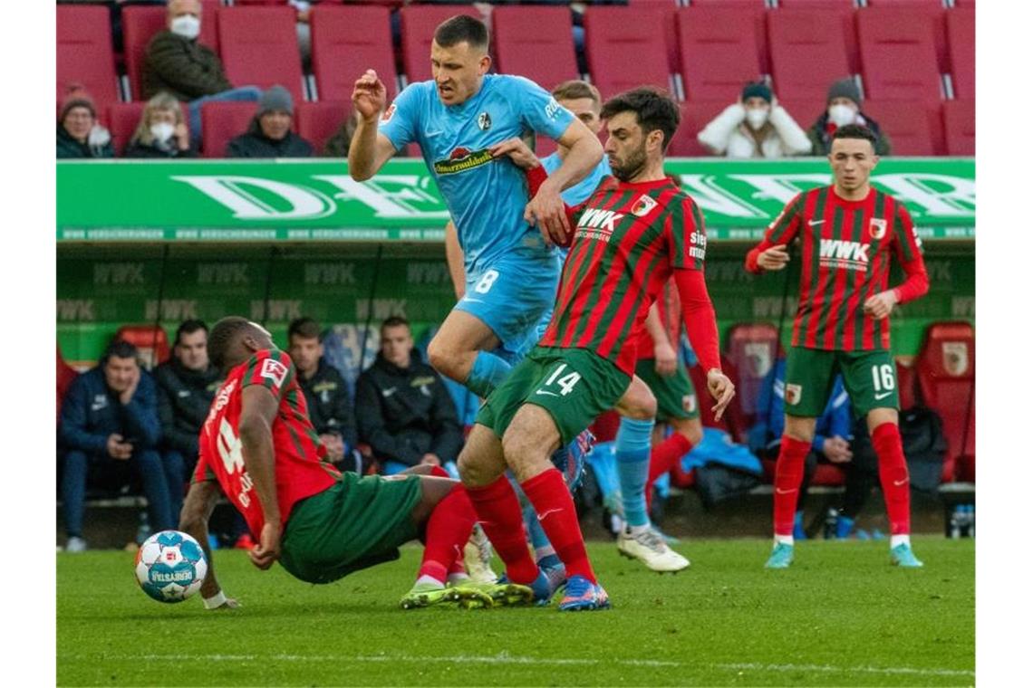 Bundesliga-Samstag: Ein Abstiegskandidat siegt, zwei patzen Die Augsburger Reece Oxford (l), Jan Moravek und Ruben Vargas können Freiburgs Maximilian Eggestein (M) nicht stoppen. Foto: Stefan Puchner/dpa