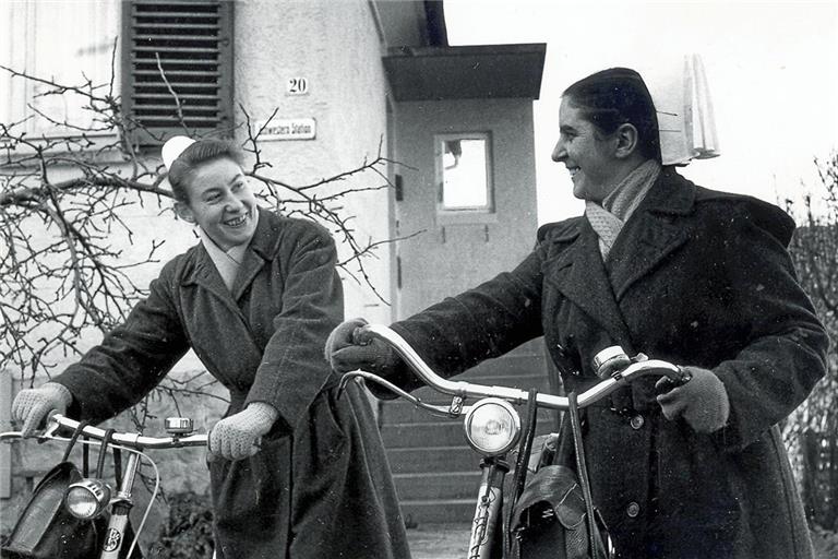 Die beiden Gemeindeschwestern Hanne Fetzer und Meta Wörner (von links), die mit Fahrrädern unterwegs waren, 1964 vor dem Aufgang zur Schwesternstation. Das modernisierte Gebäude ist heute der Sitz von Diakonie ambulant. Fotos: Diakoneo/Diak-Archiv Schwäbisch Hall