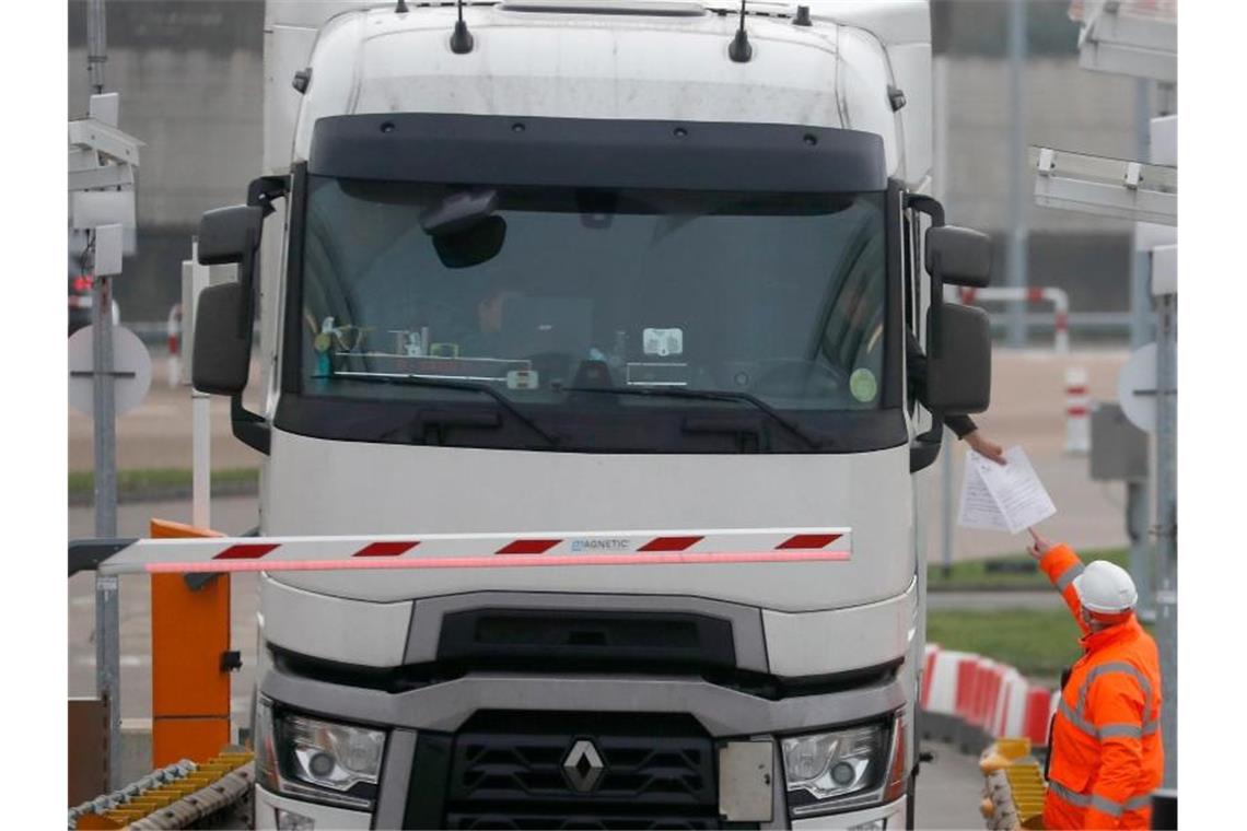 London: Einheimische Arbeitskräfte sollen LKW fahren Die Dokumente eines Lastwagenfahrers werden kontrolliert, als der Lkw den Check-in für den Zug durch den Eurotunnel passiert. Foto: Frank Augstein/AP/dpa