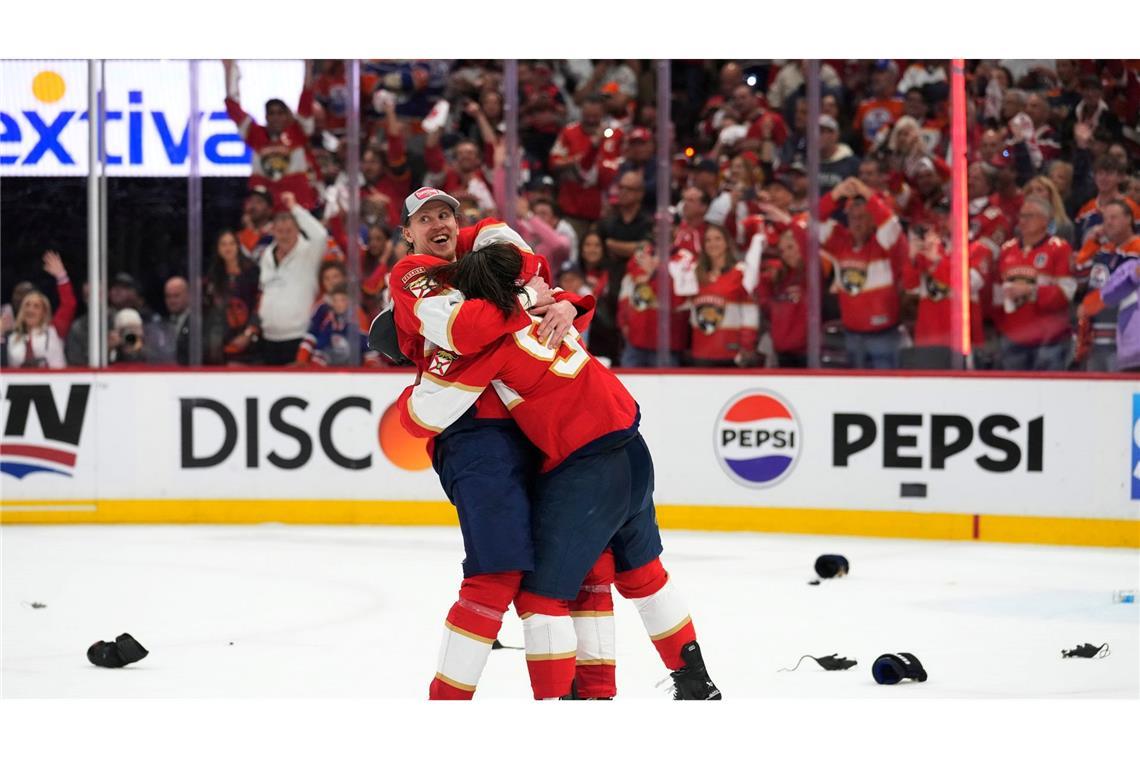 Die Eishockey-Champions liegen sich in den Armen: Die Florida Panthers um Niko Mikkola (l) und Ryan Lomberg feiern ihre erste Meisterschaft in der NHL. Im entscheidenden siebten Spiel der Serie schlugen sie die Edmonton Oilers mit 2:1.