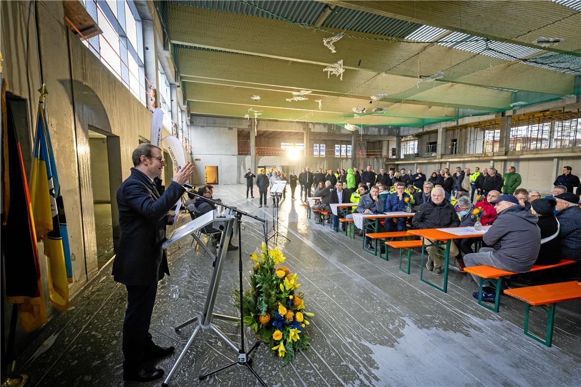 Die erste Veranstaltung in der neuen Halle hat noch nichts mit Sport zu tun: Oberbürgermeister Maximilian Friedrich begrüßt Handwerker und geladene Gäste zum Richtfest im noch offenen Rohbau.Foto: Alexander Becher