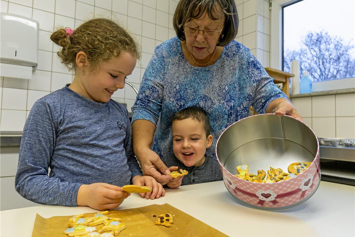 Die fertigen Plätzchen legen Nina, ihr kleiner Bruder Tim und Großmutter Rita Riske in die mitgebrachte Gutsledose. Fotos: Alexander Becher