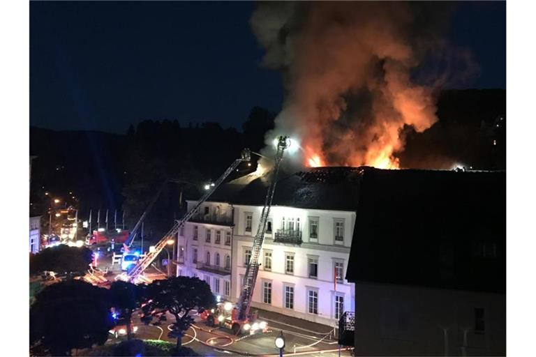 Die Feuerwehr löscht von Drehleitern aus das Hotel „Badischer Hof“. Foto: Patrick Neumann/SWR/dpa