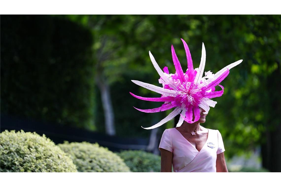 Die Hut-Show geht weiter: Eine Dame mit einem beeindruckenden, blütenförmigen Hut, der in leuchtendem Pink auf dem Gelände des Royal Ascot Pferderennens erstrahlt.